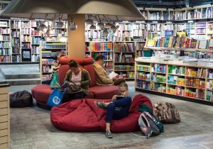 Comfortably browse our online store-Look over our products and site. Bring a friend! (Image is of a bookstore with plenty of soft-seating and bean bags. Multiple people in photo.